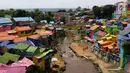 Suasana kampung warna-warni dari atas jembatan yang dipisah oleh Sungai Brantas di Kelurahan Kesatrian, Kota Malang, Minggu (5/11). Ide mengecat kampung ini berawal muncul dari sejumlah mahasiswa UMM. (Liputan6.com/Fery Pradolo)