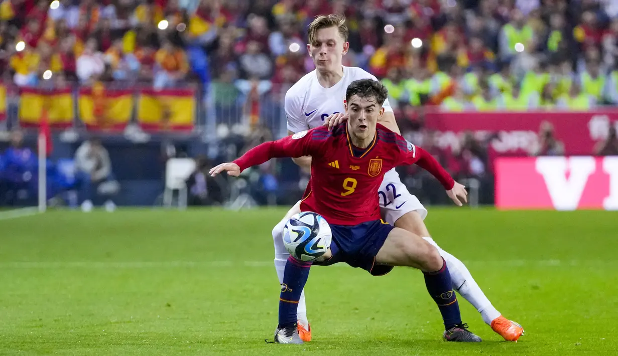 Pemain Spanyol, Gavi, berebut bola dengan pemain Norwegia, Marcus Pedersen pada laga pembuka Grup A Kualifikasi Euro 2024 di Estadio La Rosaleda, Malaga, Minggu (26/3/2023). (AP Photo/Manu Fernandez)