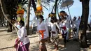 Umat Hindu membawa persembahan saat upacara Melasti menjelang Hari Raya Nyepi di Pantai Kuta, Bali (11/3/2021). Upacara Melasti dilakukan oleh perwakilan desa adat dengan jumlah terbatas serta menerapkan protokol kesehatan untuk mencegah penyebaran pandemi COVID-19. (AFP/Sonny Tumbelaka)