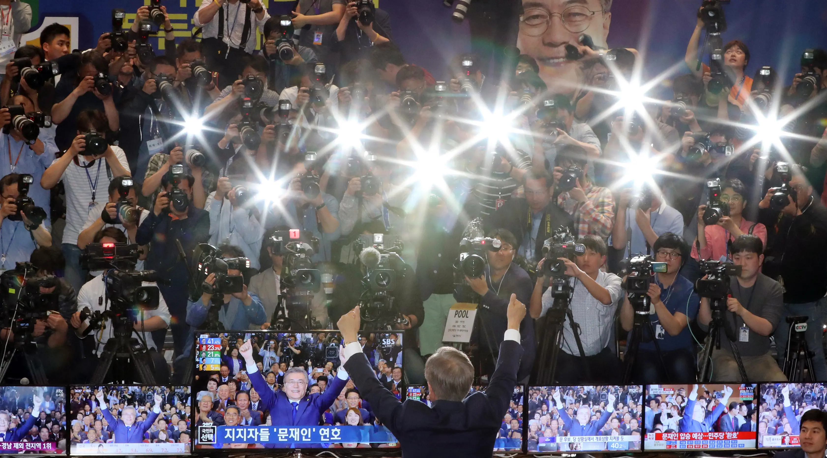 Kandidat Presiden Korsel, Moon Jae-in mengangkat tangan usai hasil hitung cepat memperlihatkan dia unggul dibanding calon lainnya di Seoul, Selasa (9/5). Calon Partai Demokrat itu menang telak dengan mengantongi 41,4 persen suara. (AP Photo/Lee Jin-man)