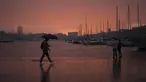 Seorang pria berjalan dengan payung saat pasangan melihat langit di Pelabuhan Vieux Marseille saat badai di Marseille, Prancis selatan, Senin (4/10/2021). Wilayah Prancis selatan dalam siaga untuk hujan lebat dan banjir. (AP Photo/Daniel Cole)