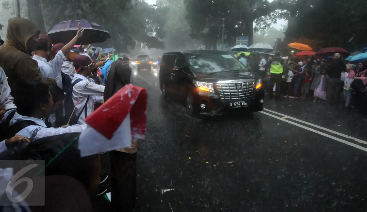 Pelajar dan warga menyambut kedatangan mobil delegasi di sekitar Istana Bogor, Rabu (1/3). Kedatangan Raja Salman bin Abdulaziz ke Istana Bogor disambut puluhan ribu pelajar dan warga. (Liputan6.com/Helmi Fithriansyah) 