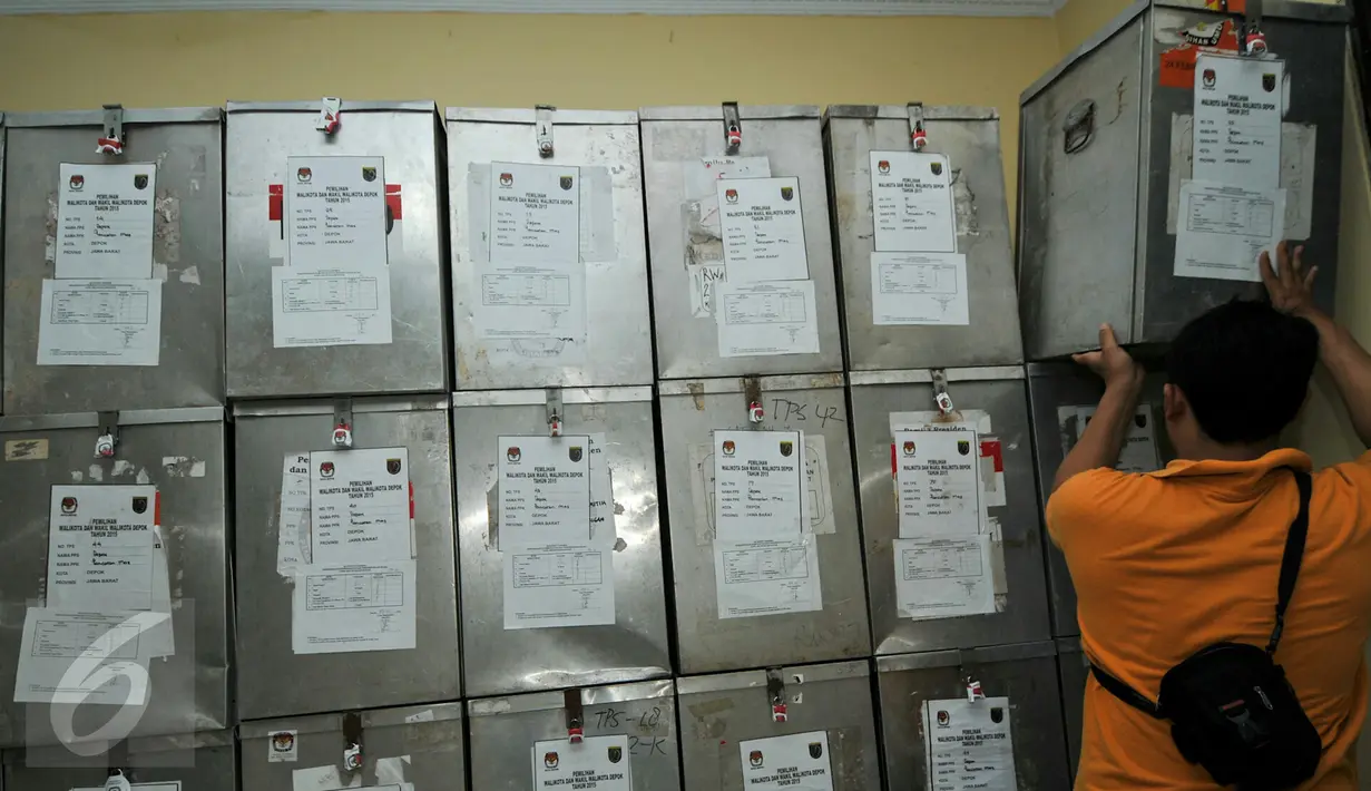 Petugas Kelurahan Depok merapihkan tumpukan kotak suara sebelum dikembalikam ke Kecamatam untuk penghitungan suara, Depok, (9/12). Kotak suara akan dibuka dan direkapitulasi ulang di kantor kecamatan. (Liputan6.com/Yoppy Renato)