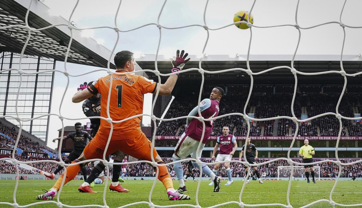 Penjaga gawang Aston Villa, Emiliano Martinez gagal membendung tendangan pemain Arsenal, Bukayo Saka (kiri bawah) yang menghasilkan gol pada pertandingan pekan ke-24 Premier League 2022/2023 yang berlangsung di Villa Park, Sabtu (18/2/2023). (AP Photo/Jon Super)