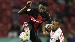 Pemain Bayer Leverkusen, Edmond Tapsoba, berebut bola dengan pemain Fortuna Duesseldorf, Suliman Marlon Mustapha, pada laga semifinal DFB Pokal di Stadion BayArena, Kamis (4/4/2024). (AP Photo/Martin Meissner)