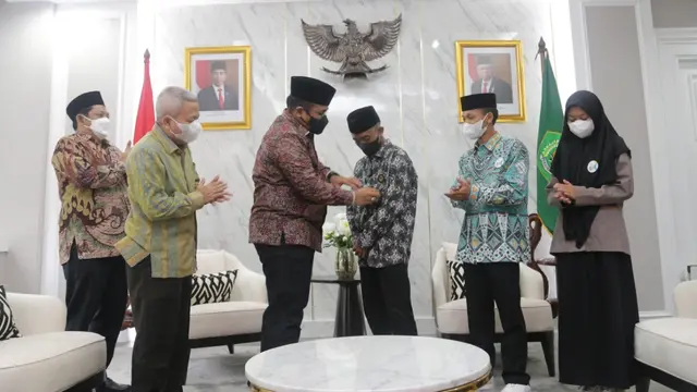 Yaqut Cholil Qoumas menyematkan pin Menteri Agama kepada pemenang Sayembara Santri Sehari Menjadi Menteri Agama Afi Ahmad Ridlo