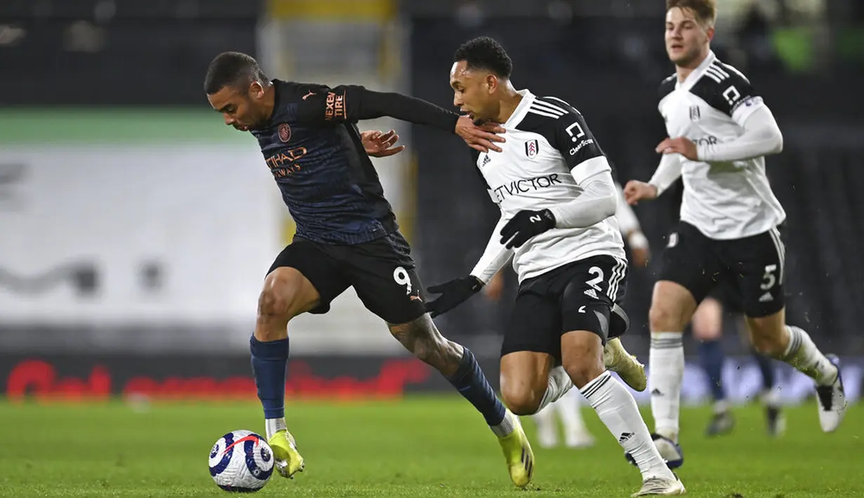 Striker Manchester City, Gabriel Jesus, berusaha melewati pemain Fulham, Kenny Tete, pada laga Liga Inggris di Stadion Craven Cottage, Sabtu (14/3/2021). City menang dengan skor 3-0. (Justin Setterfield/Pool via AP)