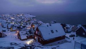 Rumah-rumah yang tertutup salju terlihat di pesisir sebuah teluk laut di Nuuk, Greenland, pada Senin (12/1/2026). (Dok. AP/Evgeniy Maloletka)