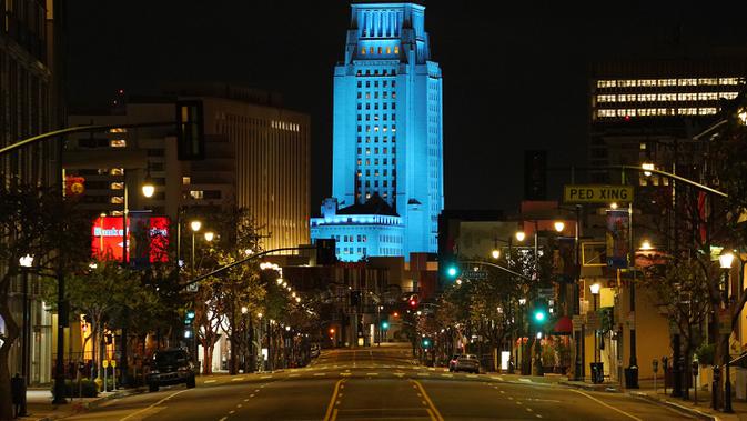BALAI KOTA LOS ANGELES MENYALA BIRU: Balai Kota Los Angeles menyala biru saat Broadway terlihat sepi, Los Angeles, AS, Jumat (10/4/2020). Balai Kota dan beberapa landmark Los Angeles menyala biru untuk menunjukkan dukungan kepada petugas medis menghadapi COVID-19. (AP Photo/Mark J. Terrill)