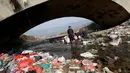 Penduduk desa mencuci pakaian di Sungai Shenling yang penuh sampah di Yuexi County, Provinsi Anhui, Tiongkok pada 14 Februari 2015. Pertumbuhan industri dan kurangnya kesadaran lingkungan membuat saluran air terkontaminas (REUTERS / William Hong)