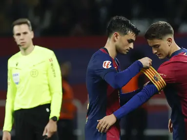 Pemain Barcelona, Gavi (kanan) menerima ban kapten saat menggantikan Pedri pada laga lanjutan Liga Spanyol 2024/2025 melawan Sevilla yang berlangsung di Estadi Olimpic Lluis Companys, Barcelona, Spanyol, Senin (21/10/2024) dini hari WIB. (AP Photo/Joan Monfort)