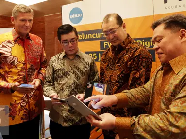 Director & Chief Agency Officer FWD Life, Hendra Thanwijaya (kanan) menunjukan aplikasi FWD kepada Jens Reisch, Kevin Mergonoto dan Leichar Solihin (ki-ka) saat peluncuran FWD Life Digital Agency di Jakarta, Senin (25/1). (Liputan6.com/Gempur M Surya)