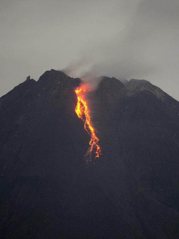 Gunung Merapi mengeluarkan lava pijar yang teramati dari Yogyakarta (7/1/2021).  Menurut Kepala PVMBG Badan Geologi Kementerian ESDM Kasbani selain guguran lava pijar, Gunung Merapi juga mengeluarkan awan panas sebanyak empat kali arah kali Krasak. (AFP/Agung Supriyanto)