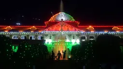 Siluet orang-orang dengan latar belakang Pengadilan Tinggi Allahabad yang diterangi pada malam Hari Kemerdekaan India di Prayagraj pada tanggal 14 Agustus 2023. (Photo by Sanjay KANOJIA / AFP)