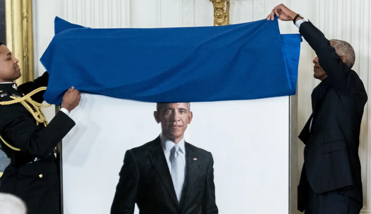 Mantan Presiden AS Barack Obama memamerkan potret resmi dari lukisannya yang akan menjadi koleksi Gedung Putih di Ruang Timur Gedung Putih, Washington, Rabu (7/9/2022). Dalam lukisan itu, Barack Obama memakai jas hitam dan dasi hitam, berdiri dengan latar belakang putih.  (AP Photo/Andrew Harnik)