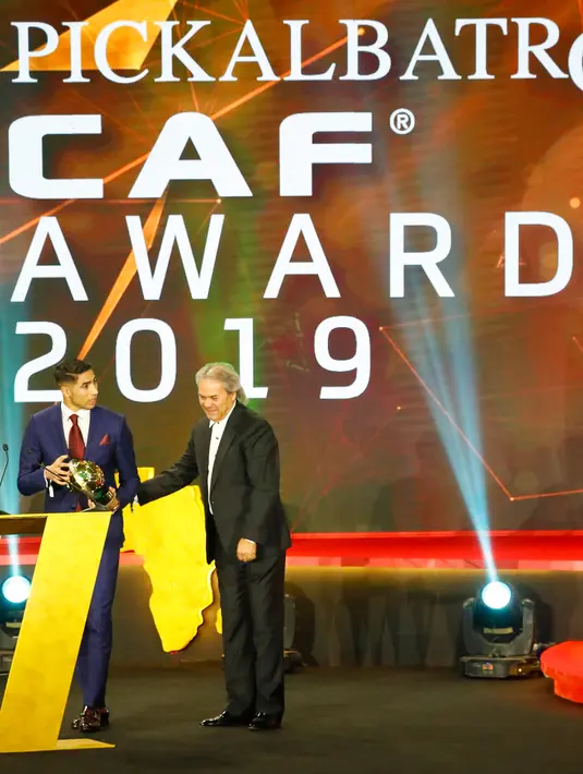 Bek berdarah Maroko, Achraf Hakimi menerima penghargaan Pemain Muda Terbaik Afrika 2019 pada acara CAF Awards di kota wisata Mesir, Hurghada, Selasa (7/1/2020). Selain Pemain Muda Terbaik Afrika 2019, acara itu juga mengumumkan beberapa penghargaan bergengsi lainnya.  (Khaled DESOUKI/AFP)