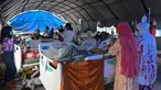 Orang-orang yang terluka dalam gempa dengan magnitudo 6,2 beristirahat di tempat penampungan sementara di luar Rumah Sakit Regional Sulbar, Mamuju, Sulawesi Barat, Minggu (17/1/2021). Mereka dirawat di dalam tenda darurat untuk mengantisipasi gempa susulan. (ADEK BERRY/AFP)