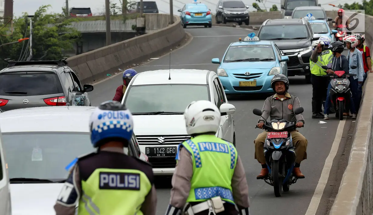 Petugas kepolisian memeriksa kelengkapan surat pengendara motor saat Operasi Zebra Jaya 2017 di Daan Mogot, Jakarta, Selasa (7/11). Operasi Zebra yang digelar 1 November- 14 Desember 2017. (Liputan6.com/Johan Tallo)