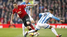 Gelandang Manchester United, Nemanja Matic, berusaha melewati pemain Huddersfield pada laga Premier League di Stadion Old Trafford, Rabu (26/12). Manchester United menang 3-1 atas Huddersfield. (AP/Martin Rickett)