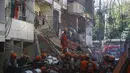 Petugas pemadam kebakaran mencari korban selamat setelah tertimpa puing-puing bangunan empat lantai yang runtuh di kawasan kumuh Rio das Pedras di Rio de Janeiro, Brasil (3/6/2021). Konstruksi tak beraturan di lingkungan kelas pekerja itu, ambruk sekitar pukul 03:20. (AP Photo/Bruna Prado)