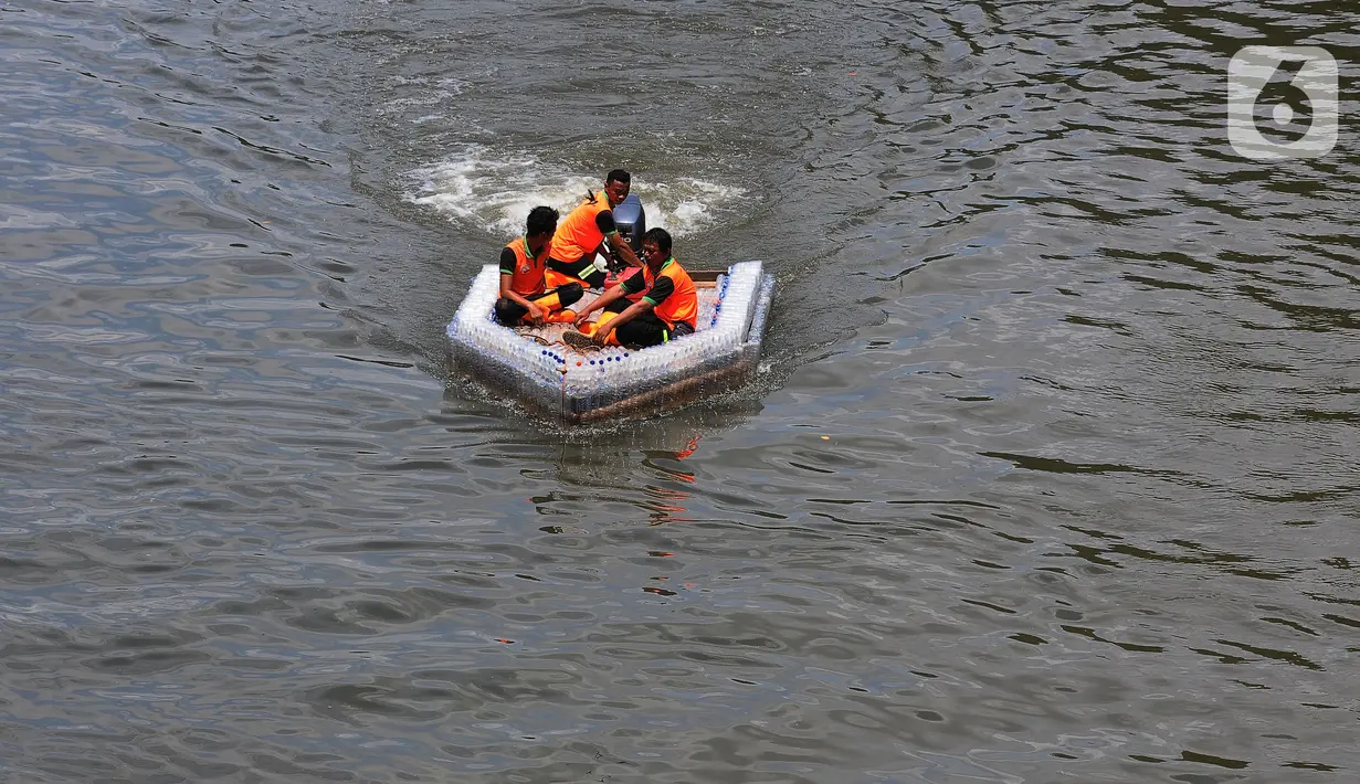 Petugas UPK Badan Air Provinsi DKI Jakarta melakukan ujicoba ketahanan dan kesimbangan perahu yang terbuat dari botol plastik bekas di aliran Kanal Banjir Timur (KBT), Jakarta, Selasa (5/3/2024). (merdeka.com/Imam Buhori)