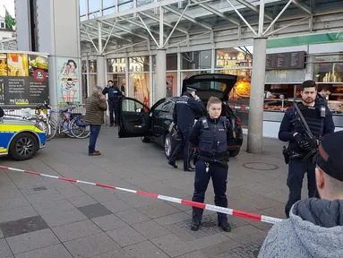 Aparat kepolisian berjaga di dekat sebuah mobil yang menabrak kerumuman orang yang tengah berdiri di depan toko roti di Heidelberg, barat daya Jerman, Sabtu (25/2). Tiga orang terluka, satu di antaranya mengalami luka serius. (R. PRIEBE/DPA/AFP)