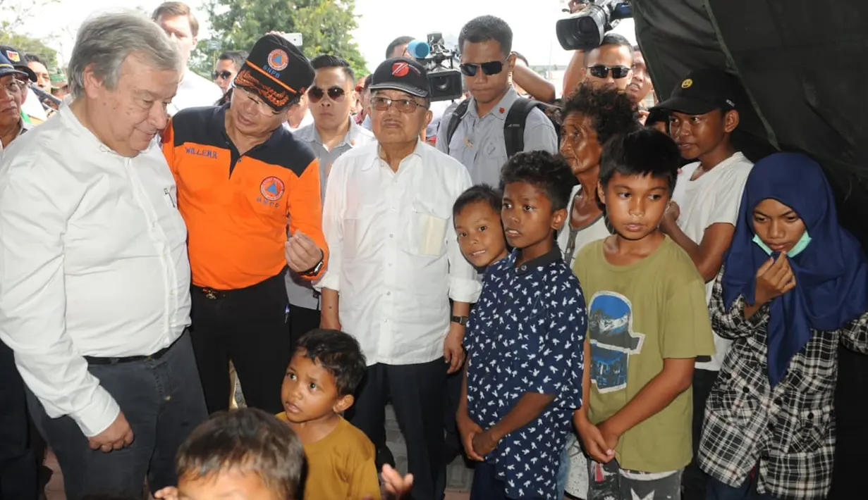 Wakil Presiden Jusuf Kalla dan Sekretaris Jenderal PBB Antonio Guterres mendengarkan penjelasan Kepala BNPB Willem Rampangilei (tengah) saat menemui korban gempa dan tsunami Palu di Sulawesi Tengah, Jumat (12/10). (Liputan6.com/HO/Tim Media Wapres)