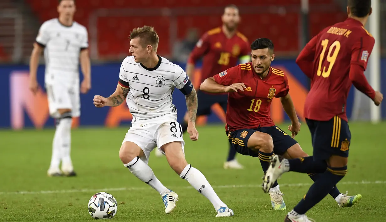 Gelandang Jerman, Toni Kroos, berebut bola dengan gelandang Spanyol, Oscar Rodriguez, pada laga Nation League di Mercedes-Benz Arena, Berlin, Jumat (4/9/2020) dini hari WIB. Jerman bermain imbang 1-1 atas Spanyol. (AFP/Thomas Kienzle)