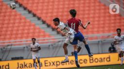 Pemain Bali United U-18 Rahmat Arjuna Reski berebut bola dengan pemain Atletico Madrid U-18 Diego Del Castillo pada laga perdana International Youth Championship (IYC) 2021 di Jakarta International Stadium (JIS), Rabu (13/4/2022). Atletico Madrid U-18 menang 5-0. (Liputan6.com/Faizal Fanani)