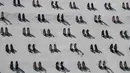 Pameran seni kontemporer yang meletakkan 440 sepatu perempuan di dinding sebuah bangunan di Istanbul, Selasa (17/9/2019). Karya seniman Turki Vahiot Tuna itu bertujuan untuk meningkatkan kesadaran perempuan tentang kekerasan dalam rumah tangga. (Ozan KOSE/AFP)