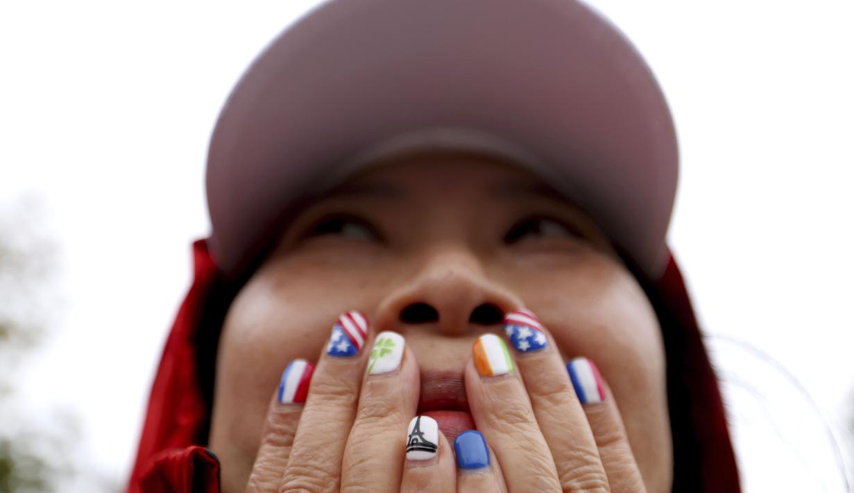 Warga tampak kagum menyaksikan acara pembukaan Olimpiade 2024 di Paris, Sabtu (27/7/2024). (AP Photo/Louise Delmotte)