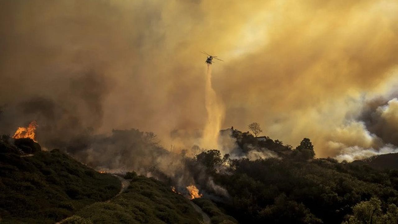 Helikopter menjatuhkan air untuk memadamkan kebakaran hutan yang terus meluas di kawasan Pacific Palisades, Los Angeles, Amerika Serikat pada Selasa, (7/1/2025).