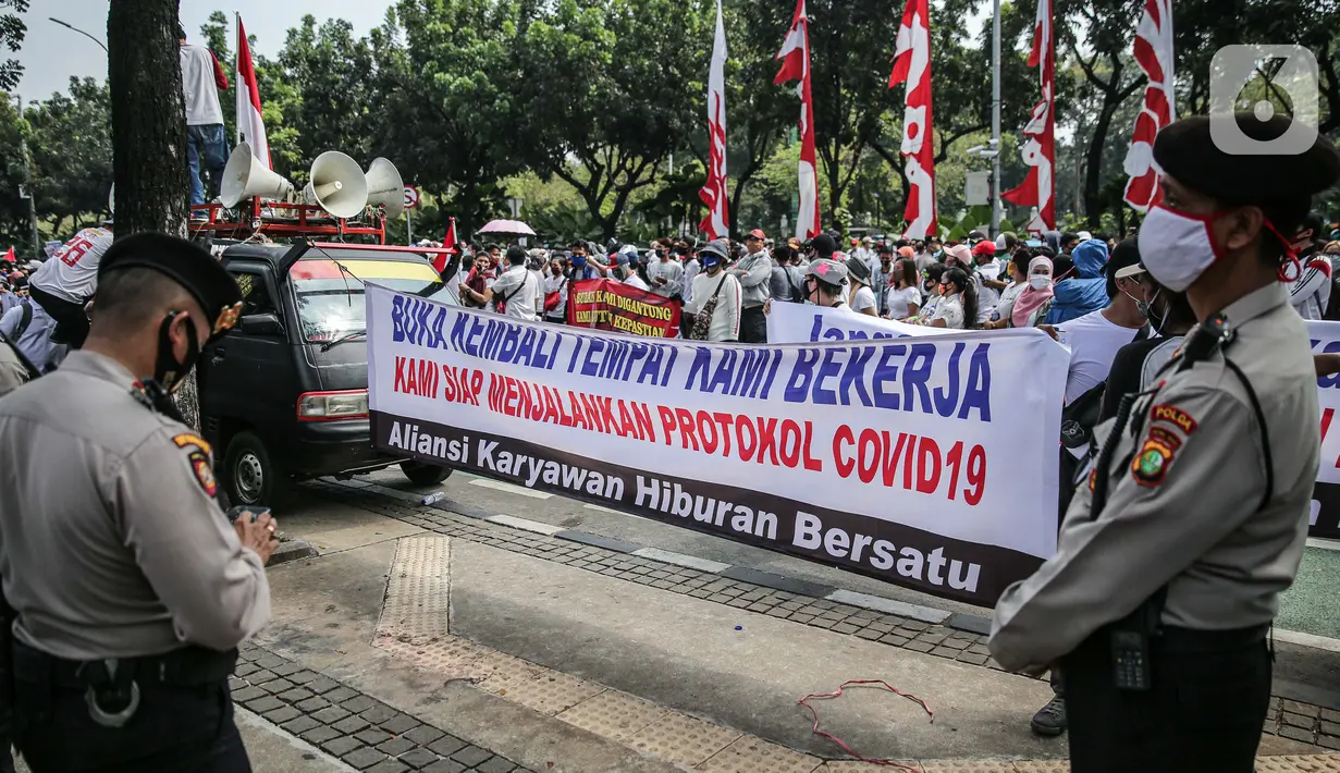 Massa yang tergabung dalam Aliansi Karyawan Hiburan dan Pengusaha Hiburan membentangkan spanduk saat menggelar aksi di depan Balai Kota DKI Jakarta, Selasa (21/7/2020). Mereka meminta Gubernur Anies Baswedan membuka usaha hiburan yang ditutup akibat pandemi COVID-19. (Liputan6.com/Faizal Fanani)