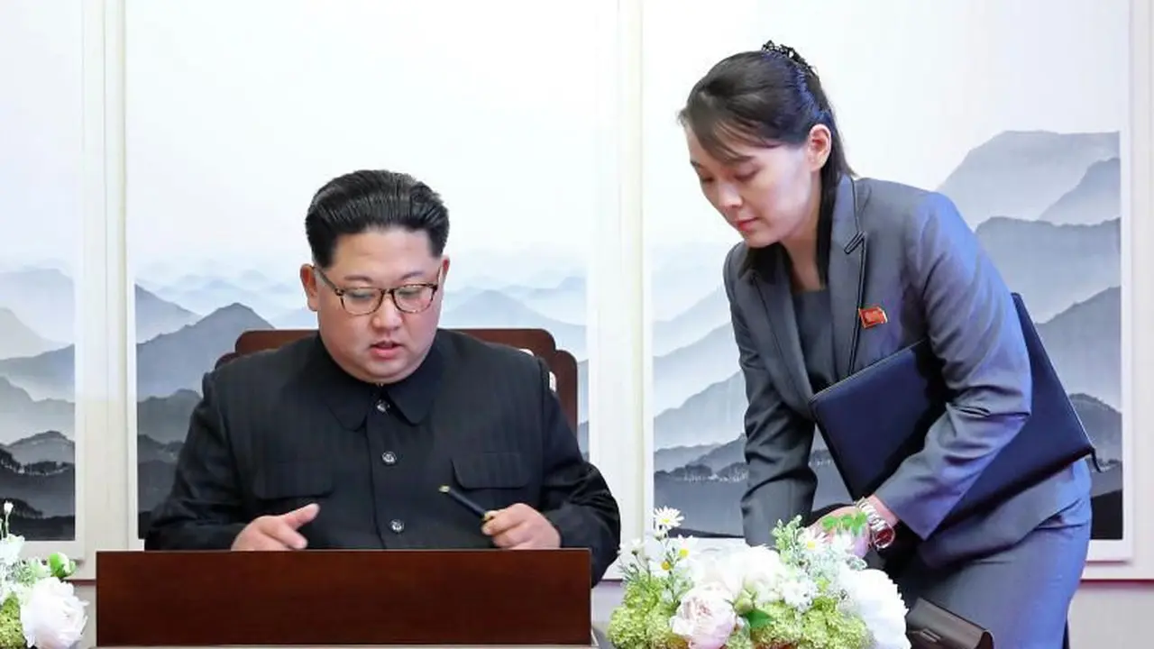 Presiden Kim Jong-un sedang menandatangani sebuah buku tamu dengan didampingi adiknya Kim Yo-jong.
