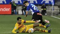 Gelandang Barcelona Sergio Busquets berebut bola dengan bek Deportivo Alaves Martin Aguirregabiria dalam duel pekan ke-22 La Liga 2021/22, di Estadio Mendizorroza, Senin (24/1/2022) dini hari WIB. Gol telat Frenkie De Jong memenangkan Barcelona 1-0. (AP Photo/Alvaro Barrientos)