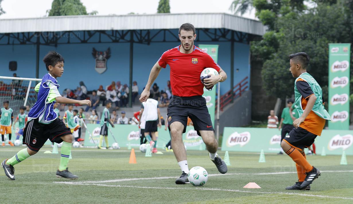 Pelatih FCBEscola, Aldric Miro, saat memberikan pelatihan MILO Football Clinic Day di Lapangan Simprug, Jakarta, Sabtu (16/12/2017). Sebanyak 500 anak mendapatkan pelatihan dasar teknik sepak bola dari pelatih berpengalaman. (Bola.com/M Iqbal Ichsan)