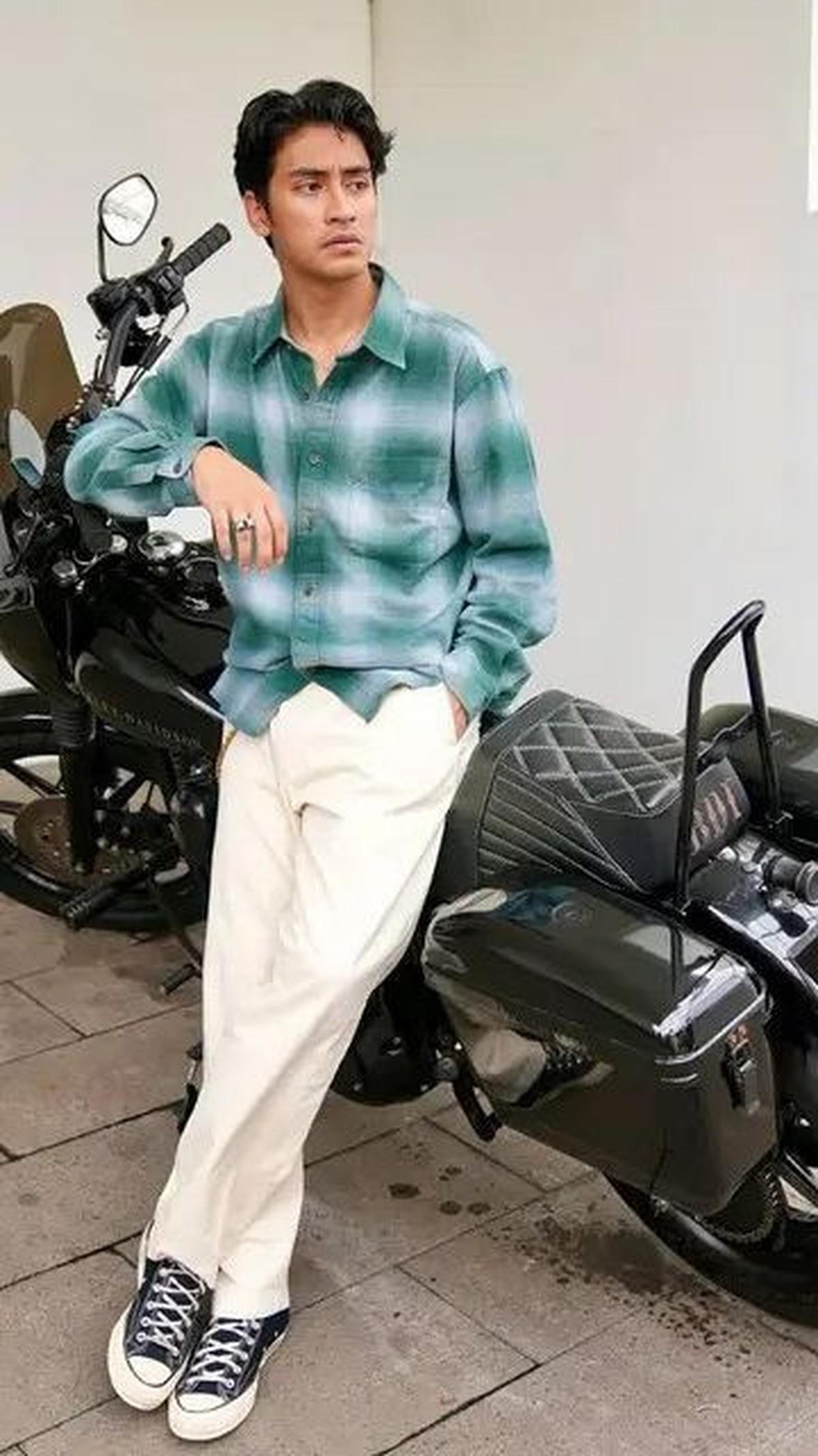 Dalam gaya yang lebih santai, Abidzar tampil mengenakan kemeja flanel hijau dan celana putih, lengkap dengan sepatu Converse.&nbsp;