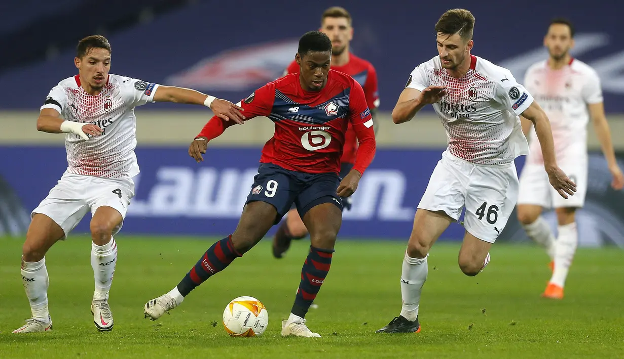 Penyerang Lille, Jonathan David (tengah) membawa bola dari kawalan bek AC Milan, Matteo Gabbia dan gelandang Ismael Bennacer pada pertandingan lanjutan Grup H Liga Europa di stadion Stade Pierre Mauroy, Prancis (26/11/2020). AC Milan bermain imbang 1-1 atas Lille. (AP Photo/Michel Spingler)