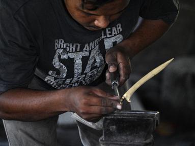 Seorang pandai besi membuat keris tradisional yang dikenal sebagai 'rencong' di sebuah bengkel di Sibreh, provinsi Aceh (5/10/2021). Rencong merupakan senjata khas Suku Aceh. (AFP/Chaideer Mahyuddin)