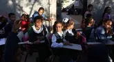 Anak-anak pengungsi Palestina menghadiri kelas di sebuah sekolah darurat di Khan Yunis di Jalur Gaza selatan pada 20 Oktober 2024. (BASHAR TALEB/AFP)