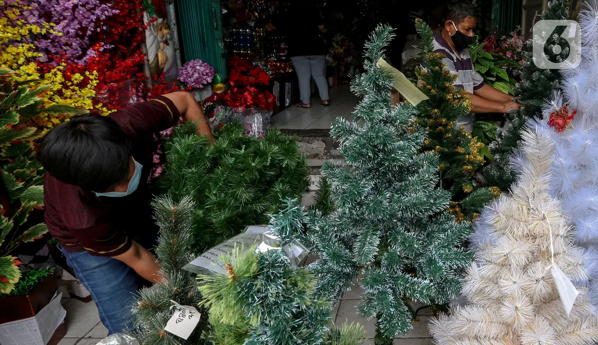 Para pedagang marapikan replika pohon Natal di Pasar Asemka, Jakarta, Rabu (16/12/2020). Pernak-pernik yang dijual di Pasar Asemka ini sangat lengkap yang dijual dimulai dengan harga Rp20.000 hingga Rp15,9 juta. (Liputan6.com/Johan Tallo)
