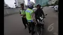 Petugas kepolisian saat memberhentikan pengendara motor ketika melintas di Jalan MH Thamrin, Jakarta, Minggu (18/1/2015). (Liputan6.com/Miftahul Hayat)