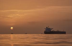 Matahari terbit di balik kapal tanker yang berlabuh di Selat Hormuz di lepas pantai Pulau Qeshm, Iran, Sabtu, 18 April 2026. (AP Photo/Asghar Besharati)