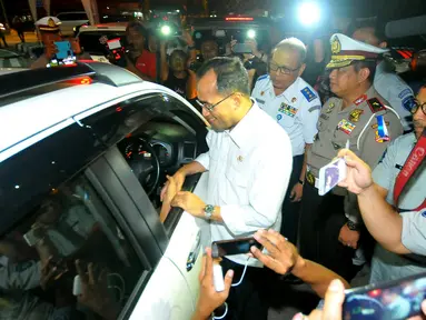 Menteri Perhubungan (Menhub) Budi Karya Sumadi saat berbincang dengan supir mobil pribadi di pintu keluar tol Brebes Timur atau Brexit Jumat (23/12). Menhub mengatakan arus lalu lintas ramai lancar pada mudik Natal 2016. (Liputan6.com/Angga Yuniar)