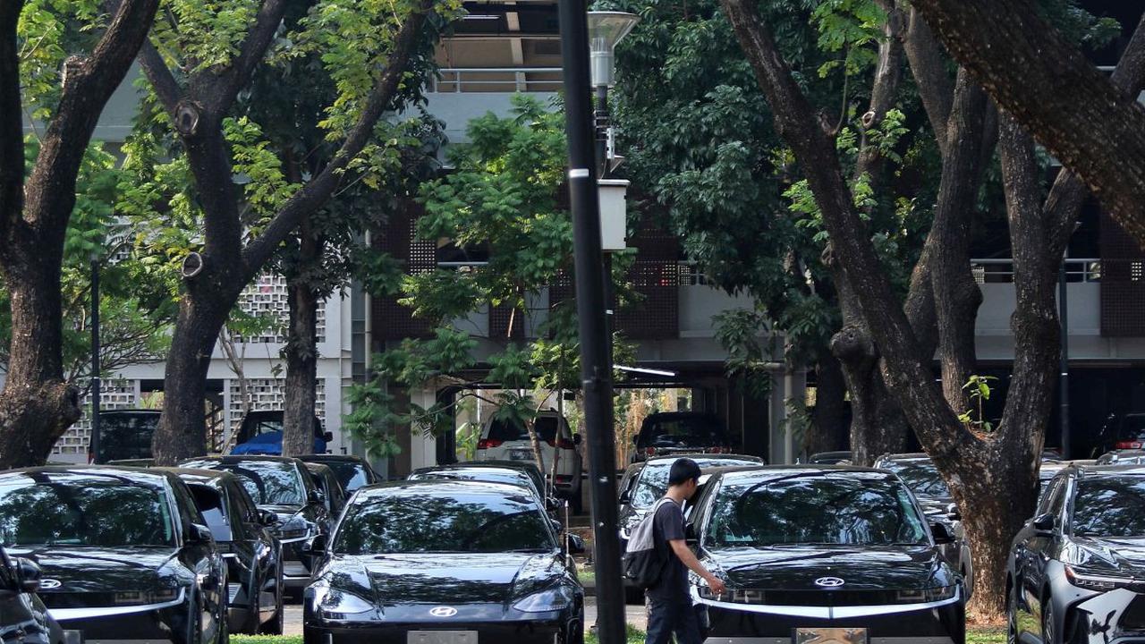 Di Parkir Timur Gelora Bung Karno (GBK) terlihat sejumlah petugas sibuk mengecek dan mempersiapkan mobil-mobil listrik dengan melakukan pemasangan pelat nomor.