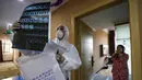 Dokter berpakaian pelindung memeriksa citra medis ketika dia mengunjungi pasien di hotel yang digunakan dalam isolasi medis virus corona di Wuhan, Provinsi Hubei, China, Senin (3/2/2020). Dokter Li Wenliang mengungkapkan penemuannya tentang virus corona kepada teman-temannya. (Chinatopix via AP)