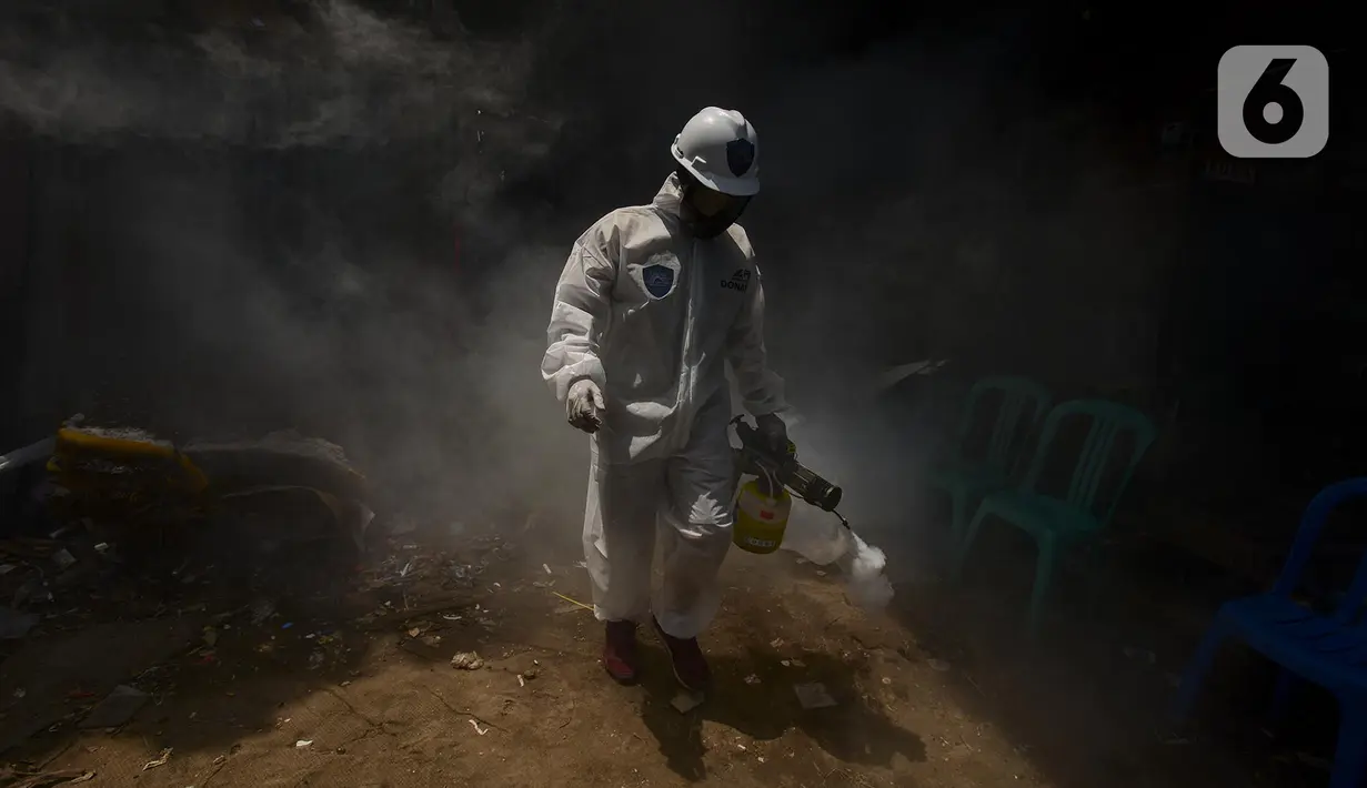 Petugas melakukan fogging nyamuk demam berdarah dengue (DBD) di kampung pemulung Pancoran, Jakarta, Rabu (22/2/2020). Pemerintah mengimbau warga mengantisipasi penyebaran DBD saat musim pancaroba pada April hingga Mei lantaran saat ini terjadi pandemi virus corona COVID-19. (merdeka.com/Imam Buhori)