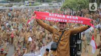 Seorang kepala desa membentangkan syal saat melakukan aksi di depan Gedung DPR RI, Jakarta, Selasa (17/1/2023). Dalam aksi yang diikuti ribuan orang tersebut mereka menuntut perpanjangan masa jabatan kepala desa yang sebelumnya enam tahun menjadi sembilan tahun dan meminta DPR RI merevisi masa jabatan yang diatur dalam UU Nomor 6 Tahun 2014 tentang Desa. (Liputan6.com/Faizal Fanani)