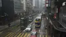 Kendaraan melewati persimpangan di daerah Causeway Bay saat badai tropis Ma-on melewati Hong Kong, Kamis (25/8/2022). Badai Tropis Ma-on semakin kuat saat menuju Hong Kong dan bagian tenggara lainnya China pada hari Rabu setelah menggusur ribuan orang di Filipina. (AP Photo/Anthony Kwan)