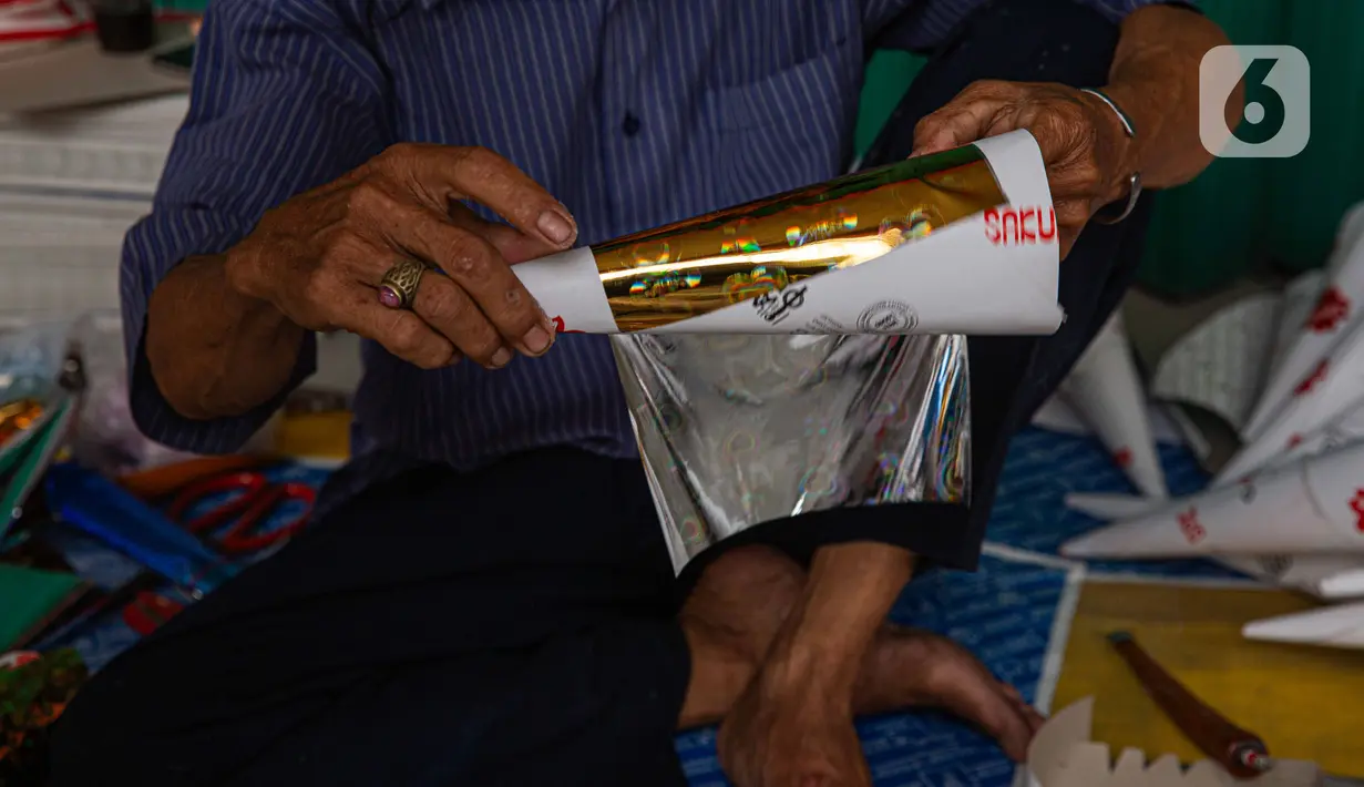Pedagang menyelesaikan pembuatan terompet di kawasan Glodok, Jakarta, Selasa (26/12/2023). (Liputan6.com/Faizal Fanani)